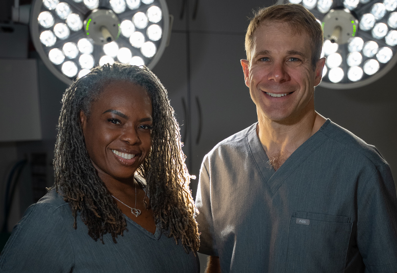 Dr. Jason Cooper and Arlene Michelle Wilson in grey scrubs inside surgical room located in Jupiter, FL